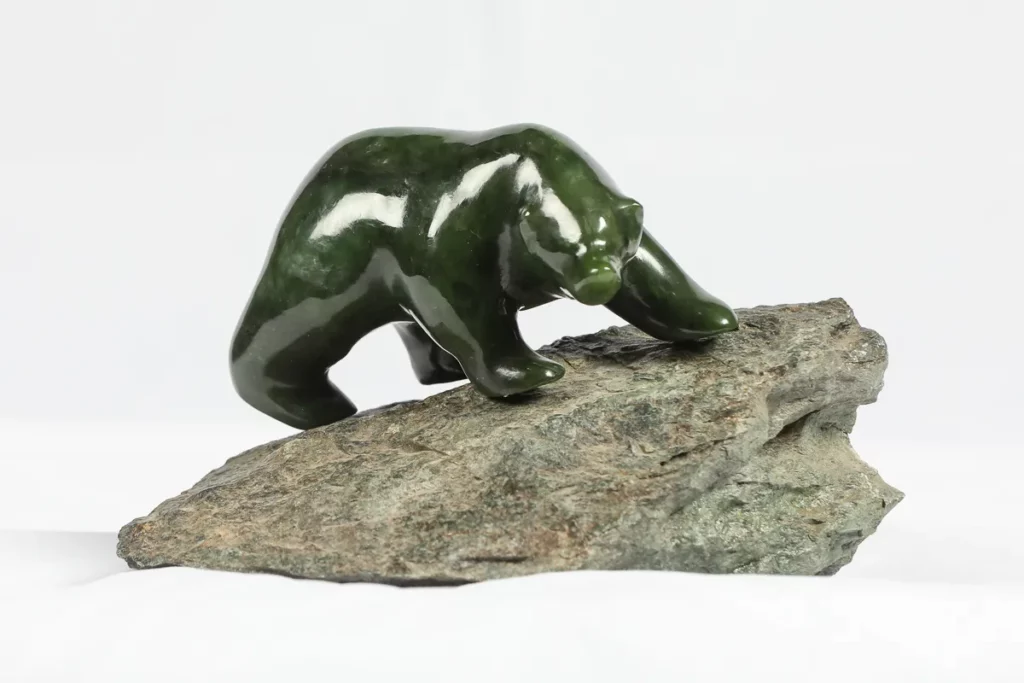 Carved BC jade bear mounted on raw unpolished rock. The contrast between the sculpted bear and its unworked base shows what hours of grinding and polishing can draw out of BC jade.