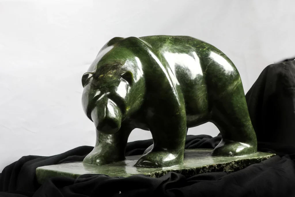 Polished green nephrite jade bear sculpture on display
